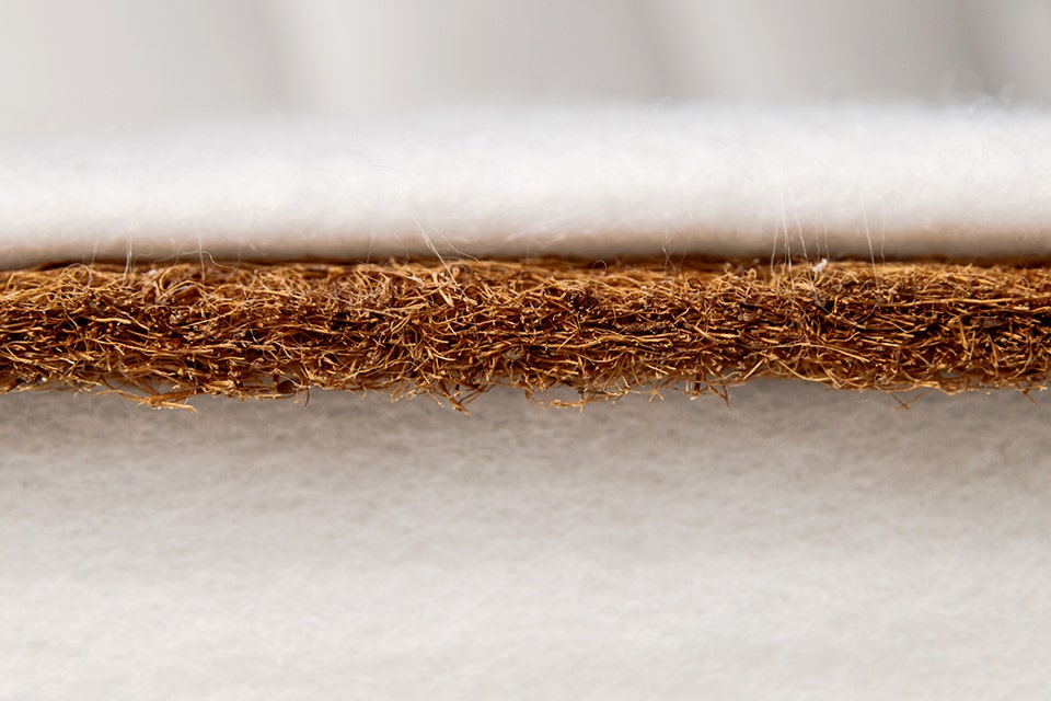 A traditional coir mattress made by layering coconut husk fibres, showcasing its natural and eco-friendly structure.