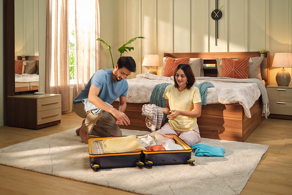 A couple packing bag and getting ready for a holiday, in a modern bedroom.