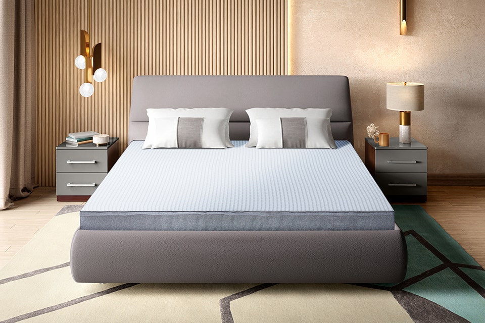 A bed with a spring mattress and two bedside tables on each side.