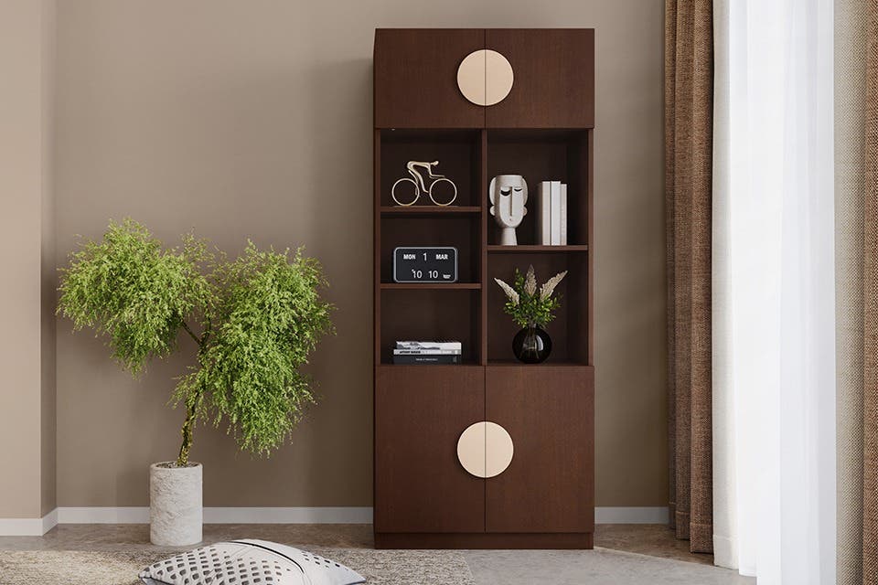 Tall wooden bookshelf in a modern living room with books and decorative accessories.