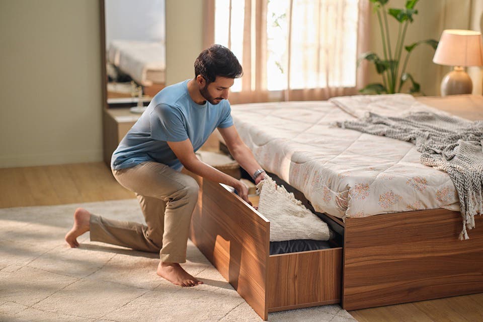 Person at a modern storage bed with under-bed storage in a compact bedroom.