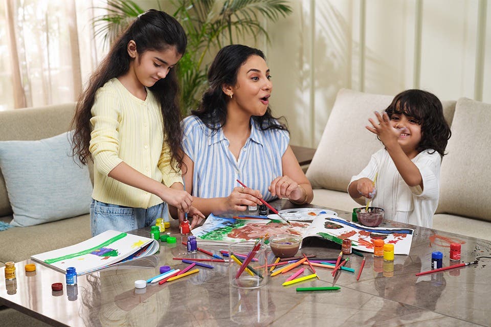 Family using a coffee table for crafts in a modern living room.