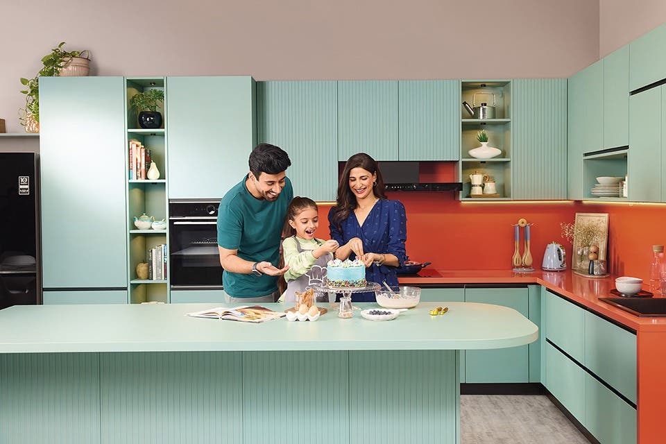 A family at a modular kitchen countertop cutting a cake.