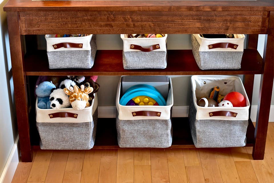 Open shelving with fabric storage baskets organising toys and household essentials.
