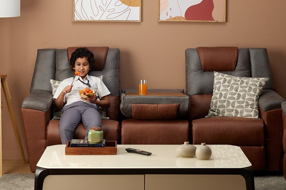 A child enjoying the comfort of a recliner sofa set.
