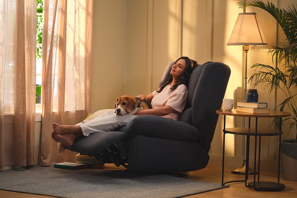 A person relaxing in a blue leather recliner chair.