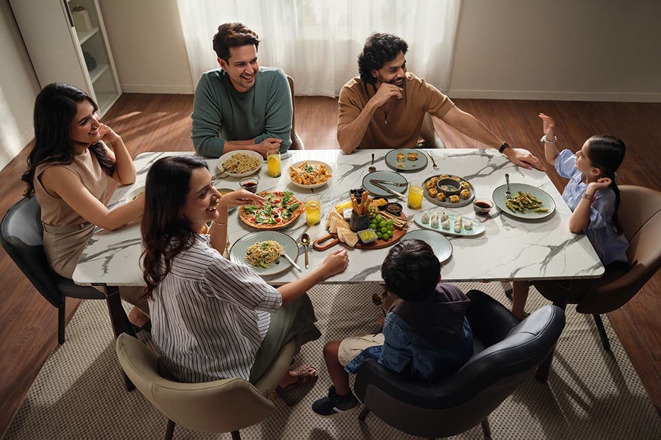 A group of people and children seated comfortably at a dining table.