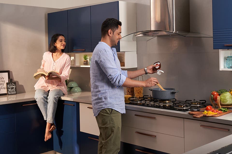 A couple in a compact modular kitchen with efficient storage, clear work surfaces and good natural light. 