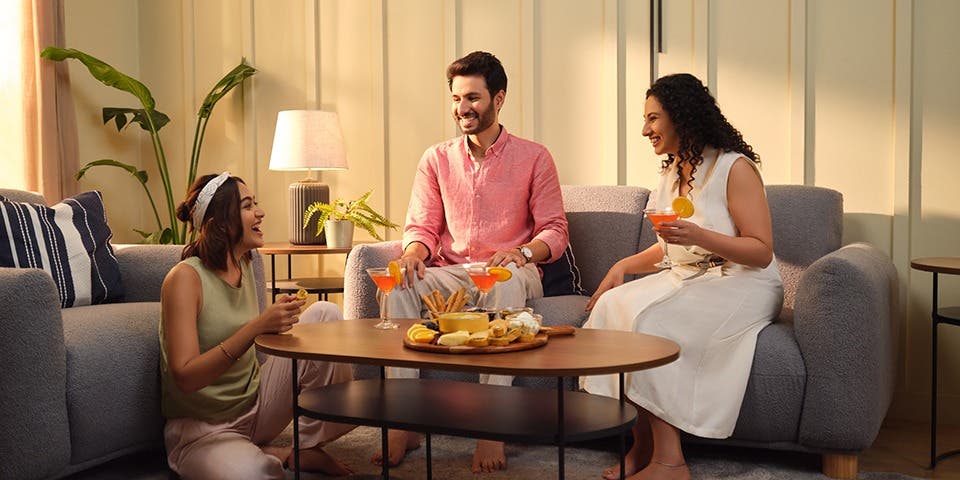 Friends sitting around and on a comfortable sofa set.