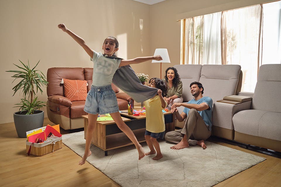 A family in a living room with a well-proportioned sofa set and coffee table.