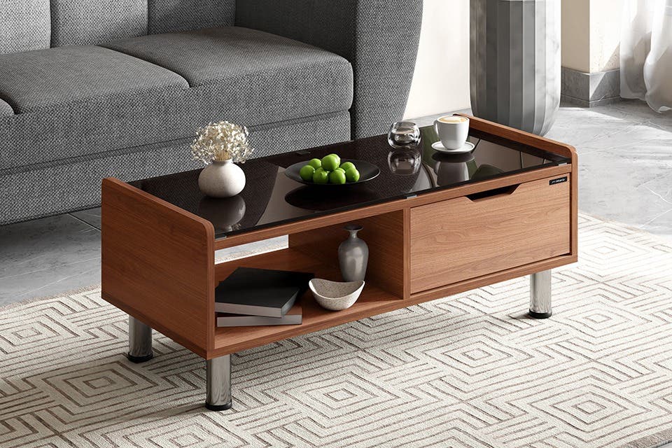 A wooden coffee table with a glass top in a modern Indian home.